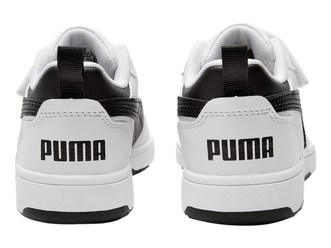 Tenis PUMA blancos con detalles negros, cierre de velcro y cordones para niño o niña.