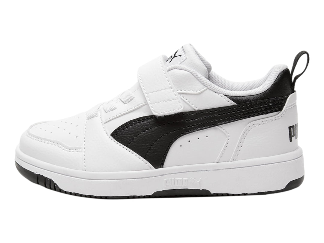 Tenis PUMA blancos con detalles negros, cierre de velcro y cordones para niño o niña.