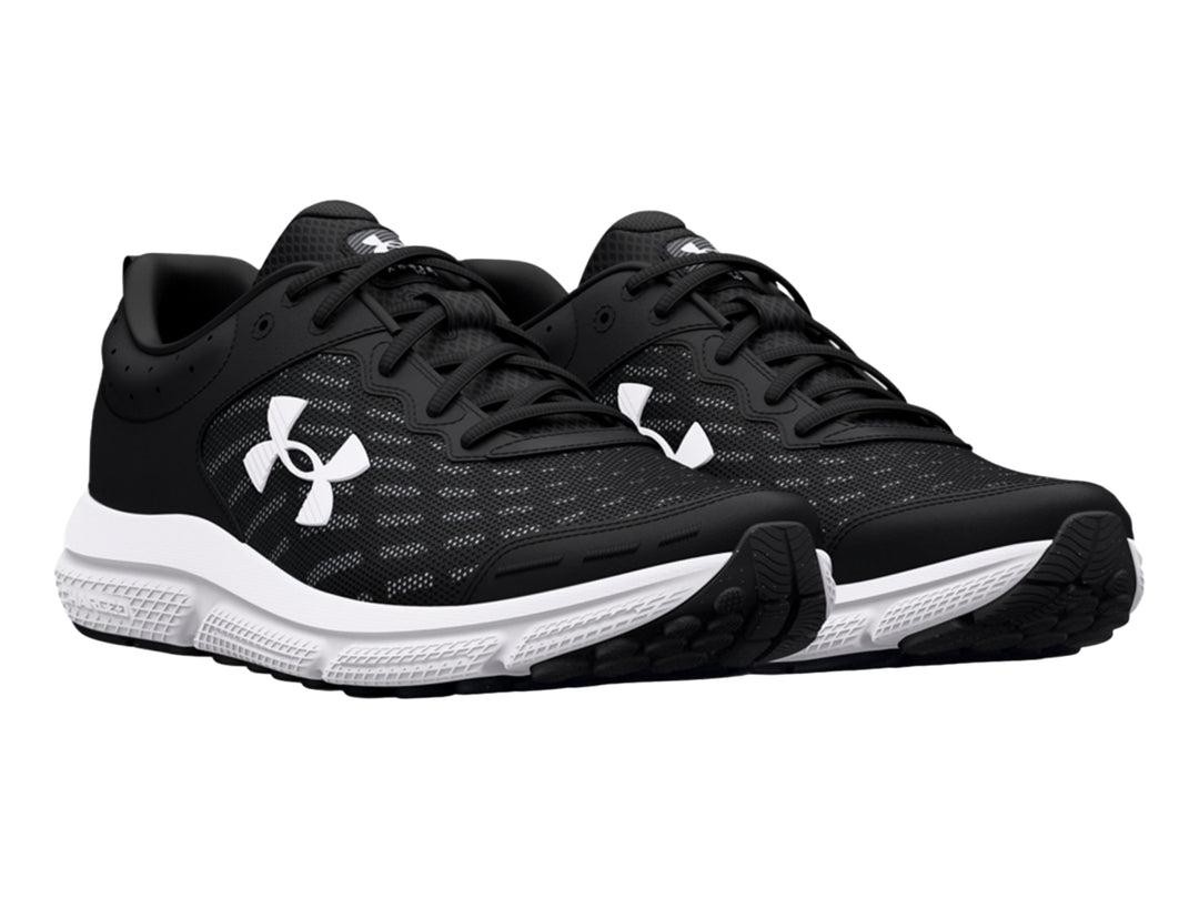 Tenis deportivos Under Armour Charged Assert 10 en color negro con suela blanca y logotipo lateral blanco.