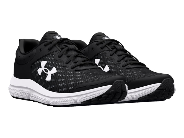 Tenis deportivos Under Armour Charged Assert 10 en color negro con suela blanca y logotipo lateral blanco.