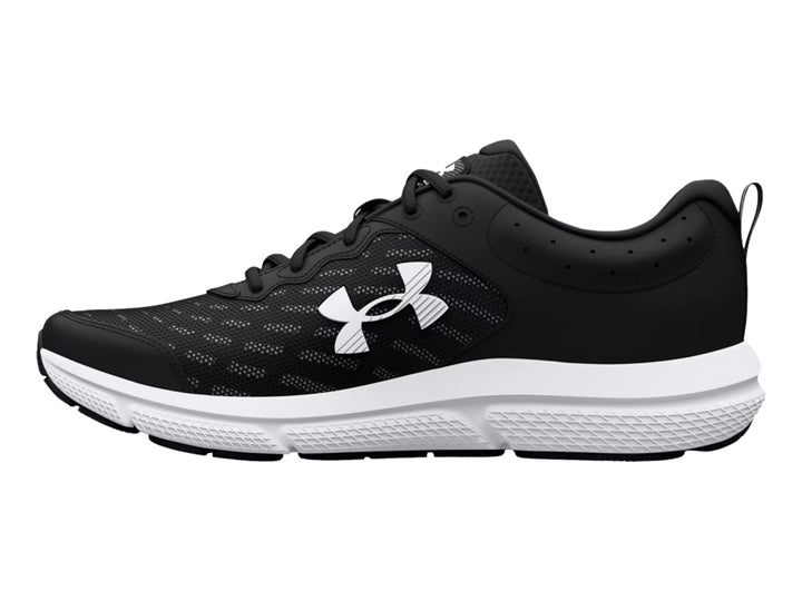 Tenis deportivos Under Armour Charged Assert 10 en color negro con suela blanca y logotipo lateral blanco.