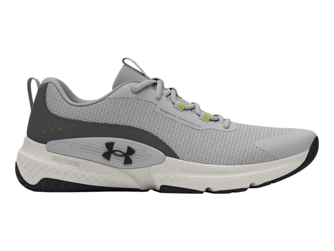 Tenis deportivos Under Armour en color gris con suela blanca y detalles en verde y negro.