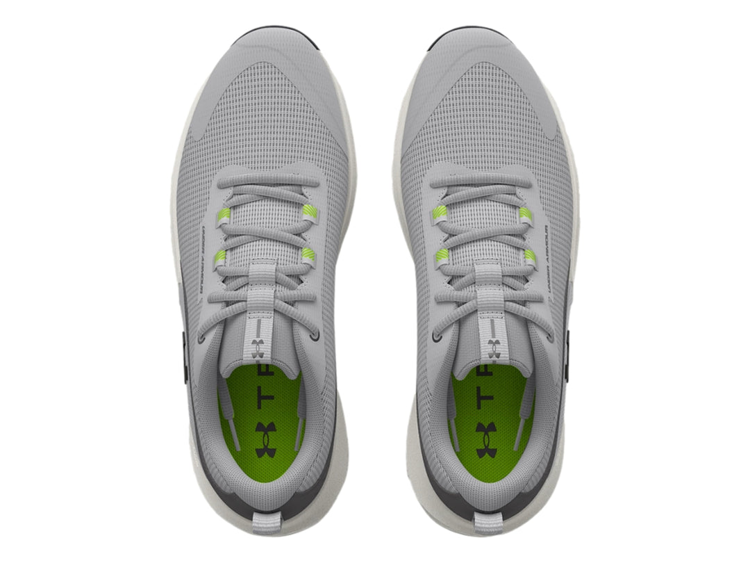 Tenis deportivos Under Armour en color gris con suela blanca y detalles en verde y negro.