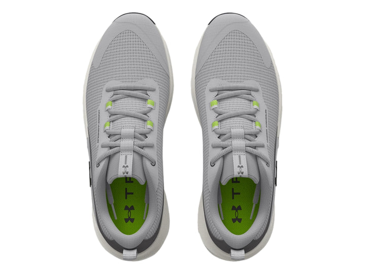 Tenis deportivos Under Armour en color gris con suela blanca y detalles en verde y negro.