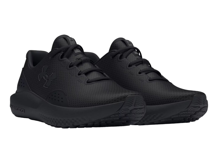 Tenis deportivos Under Armour Charged Surge 4 en color negro total con suela amortiguada.