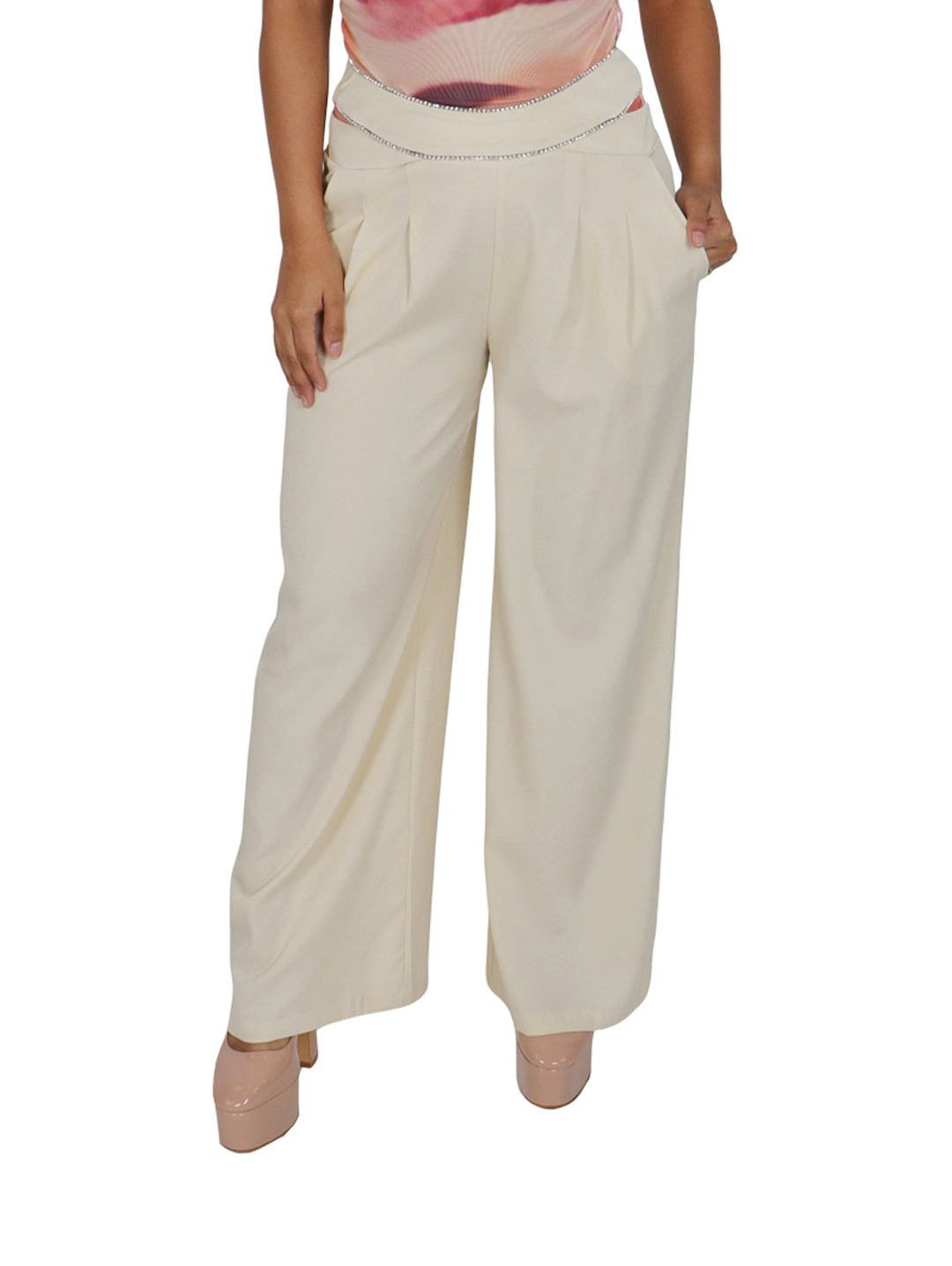 Mujer vistiendo un pantalón ancho de color beige con detalle plateado en la cintura.