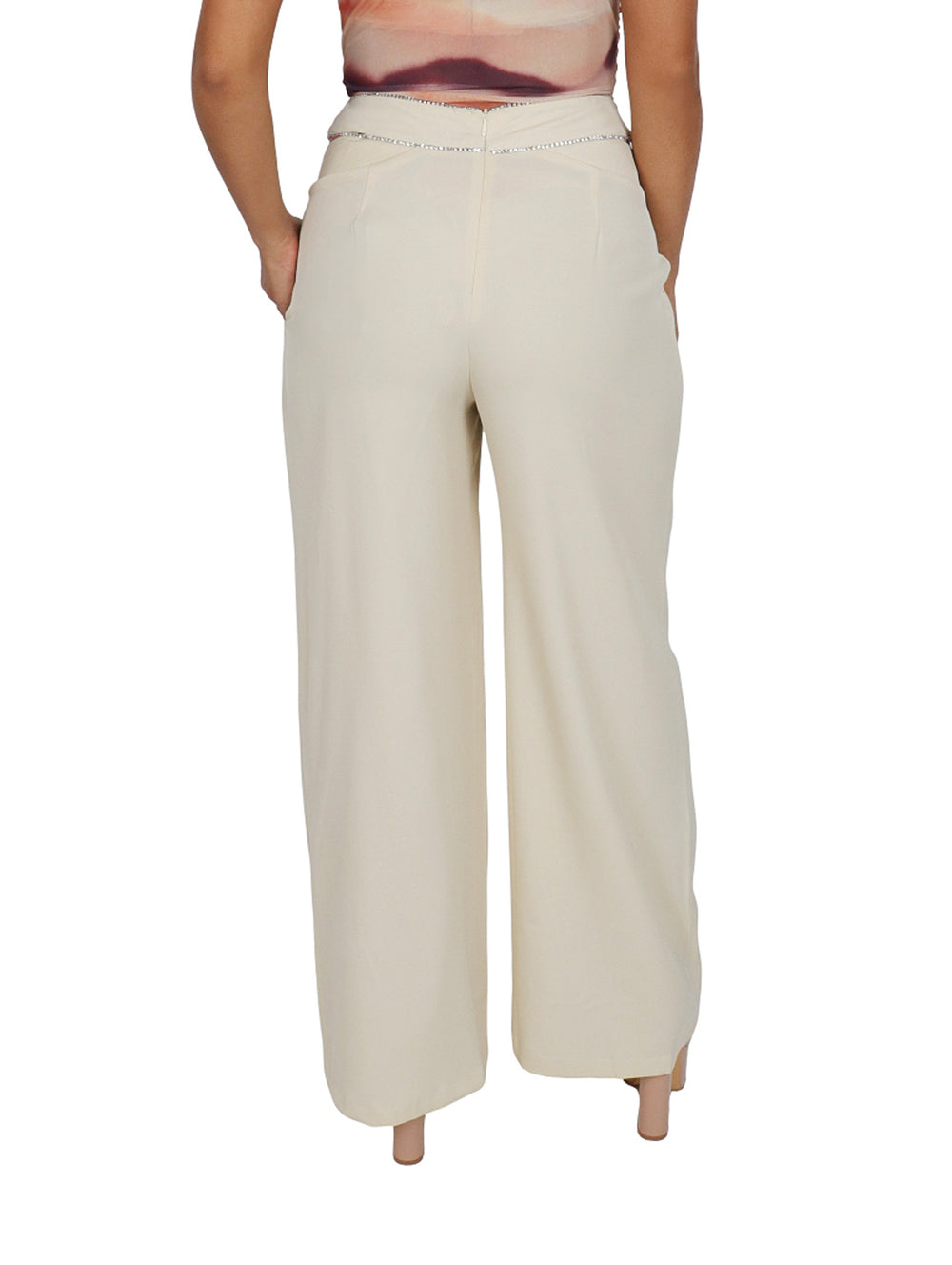 Mujer vistiendo un pantalón ancho de color beige con detalle plateado en la cintura.