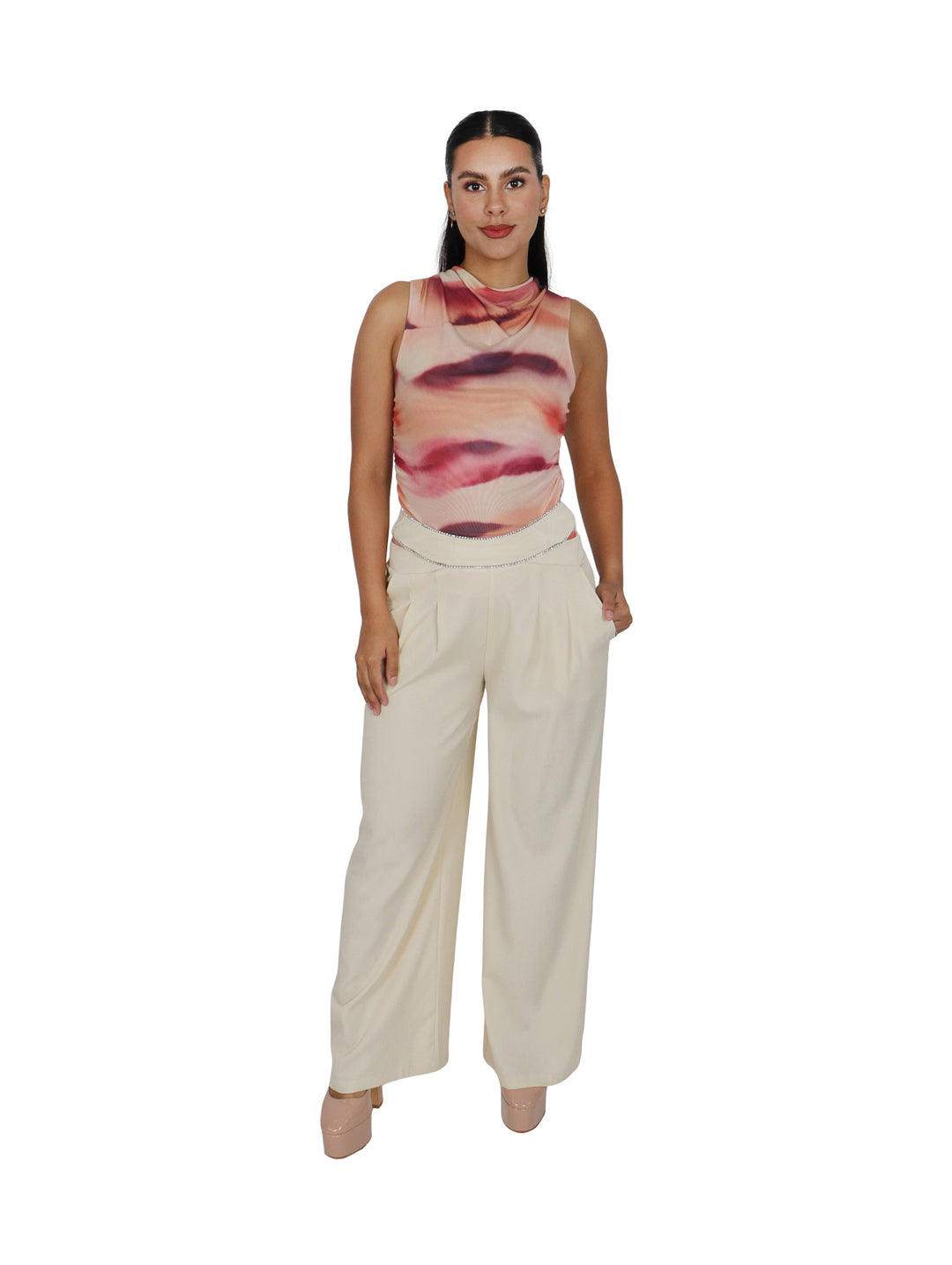 Mujer vistiendo un pantalón ancho de color beige con detalle plateado en la cintura.