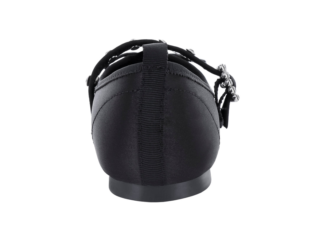 Zapato plano negro de tela brillante con hebilla decorativa plateada y punta redondeada.
