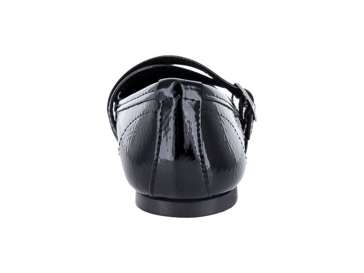 Zapato plano negro de charol arrugado con dos hebillas plateadas.