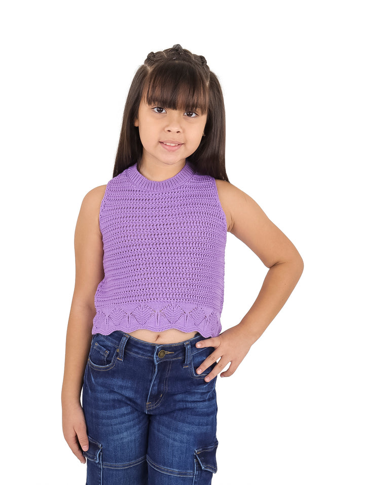 Niña vistiendo una blusa lila de crochet sin mangas y pantalones vaqueros azules.