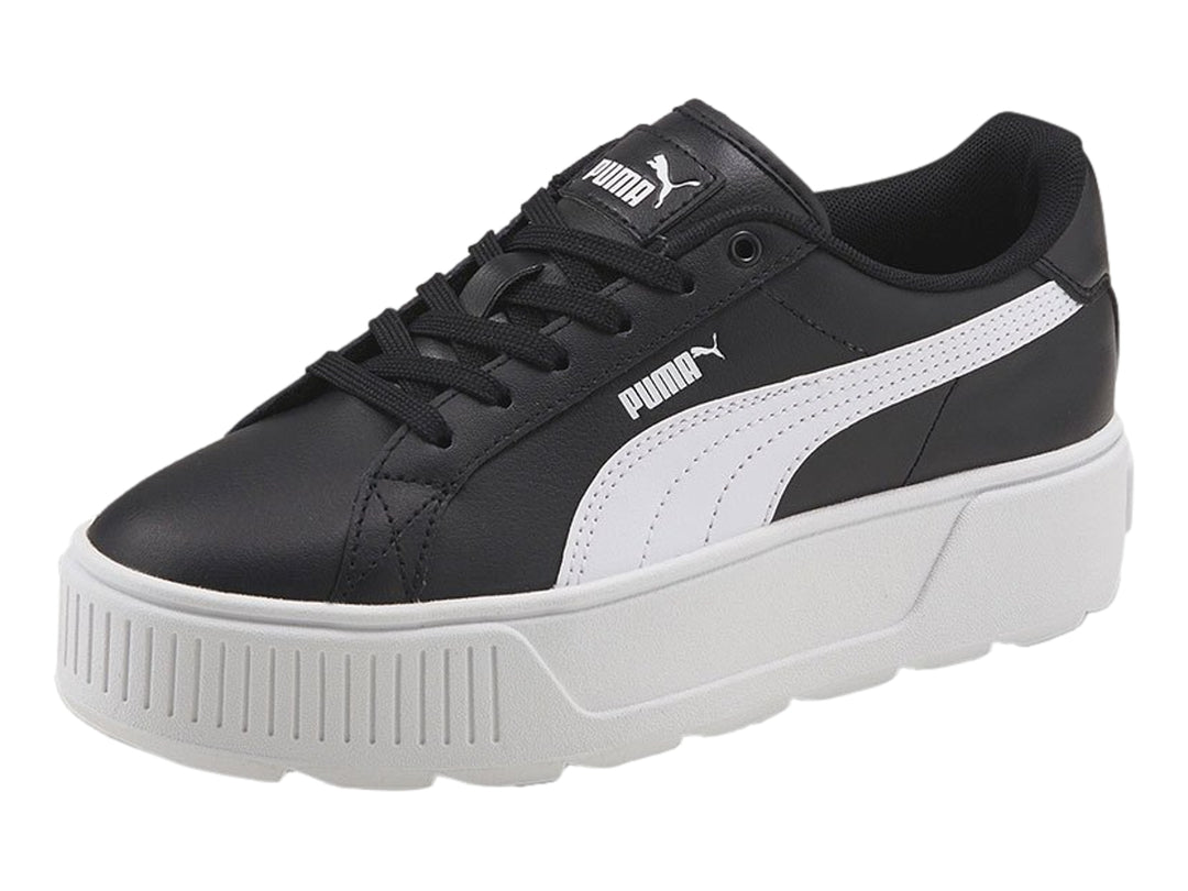 Tenis PUMA color negro con suela de plataforma blanca y franja lateral blanca.