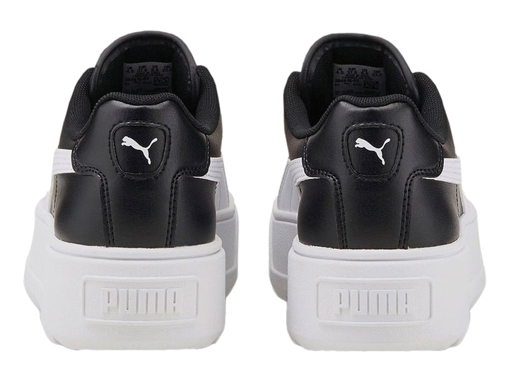 Tenis PUMA color negro con suela de plataforma blanca y franja lateral blanca.