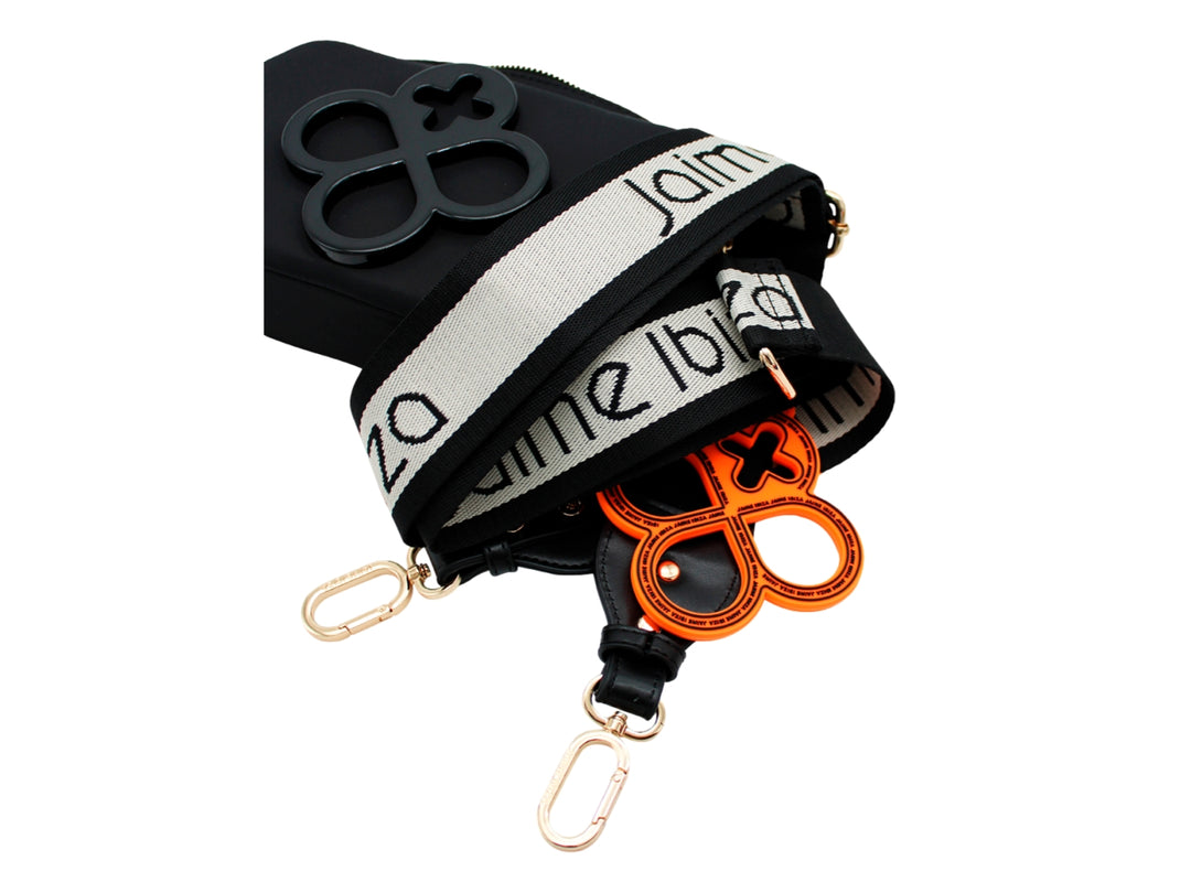 Bolso crossbody negro de Jaime Ibiza con emblema frontal decorativo y herrajes dorados.