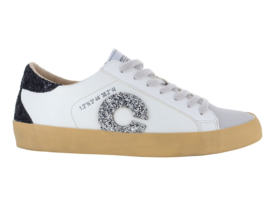 Tenis blancos casuales con detalles brillantes en negro y plata y suela color beige.