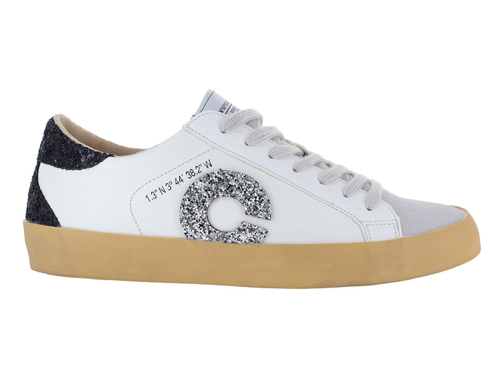 Tenis blancos casuales con detalles brillantes en negro y plata y suela color beige.