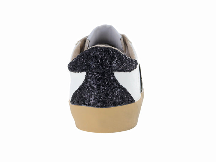 Tenis blancos casuales con detalles brillantes en negro y plata y suela color beige.