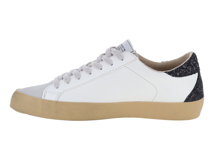 Tenis blancos casuales con detalles brillantes en negro y plata y suela color beige.