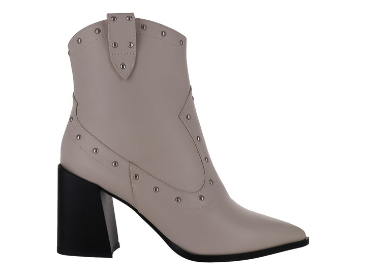 Botín color marfil con tacón cuadrado negro y detalles de estoperoles metálicos.