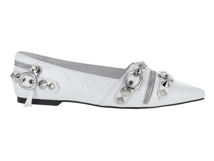 Zapato plano blanco con punta afilada, adornado con cierres y estoperoles plateados.