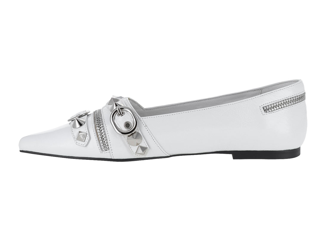 Zapato plano blanco con punta afilada, adornado con cierres y estoperoles plateados.