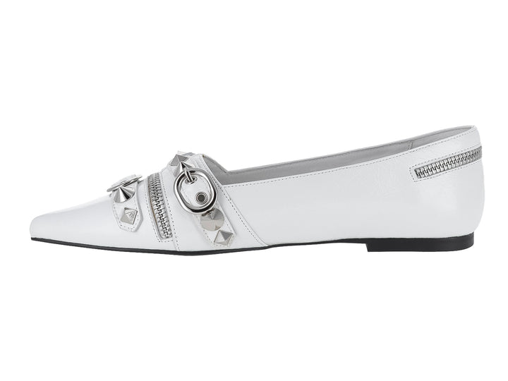 Zapato plano blanco con punta afilada, adornado con cierres y estoperoles plateados.