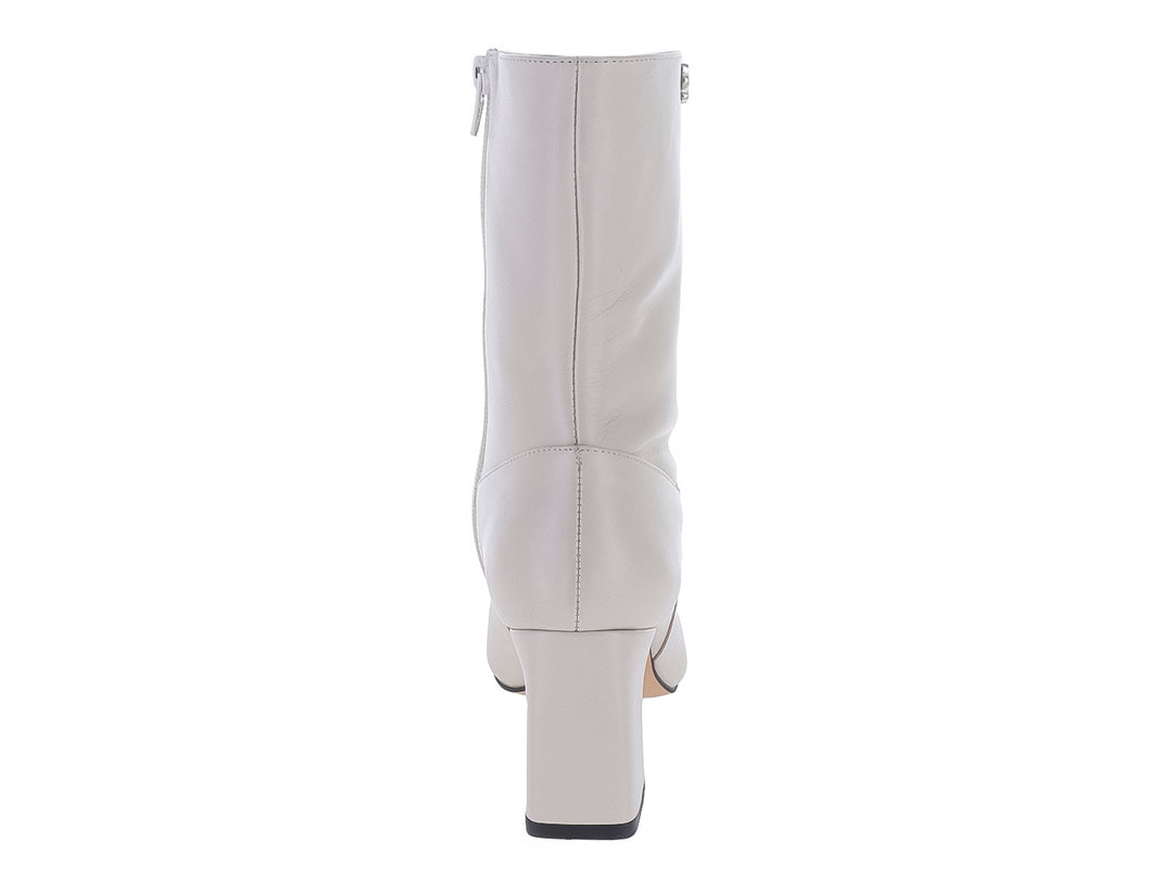 Bota de piel color marfil con tacón cuadrado y punta afilada.