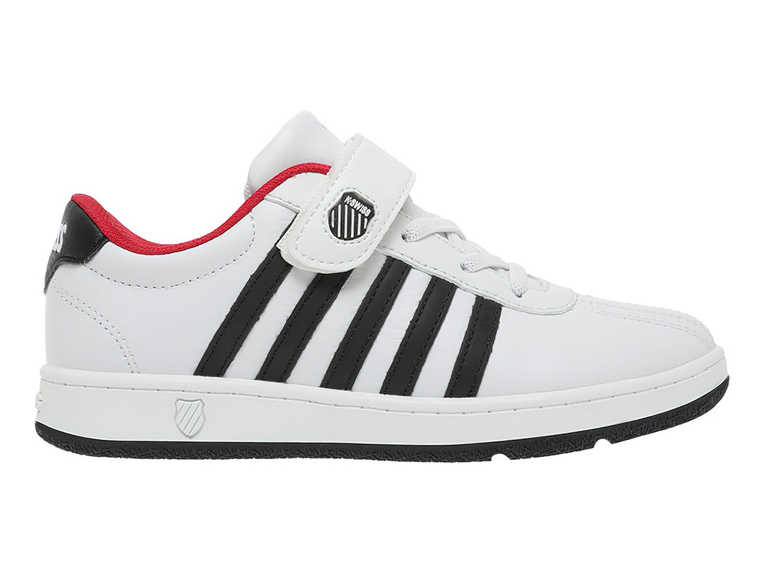 Tenis K-Swiss blancos con rayas negras laterales, detalles en rojo y cierre de correa con velcro.