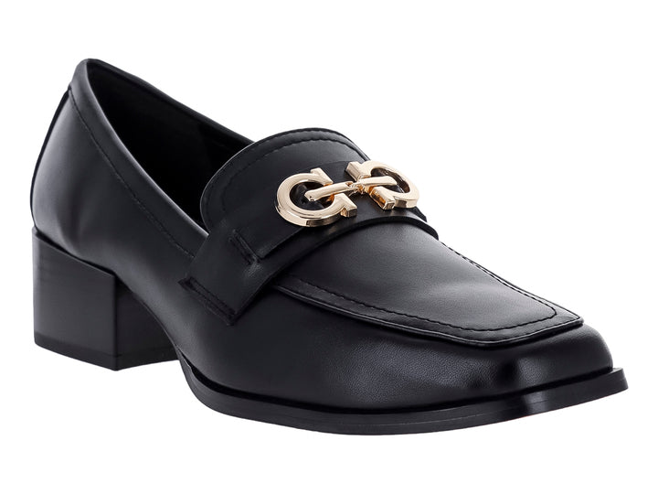 Zapato tipo mocasín color negro con tacón cuadrado y detalle metálico dorado en la parte superior.