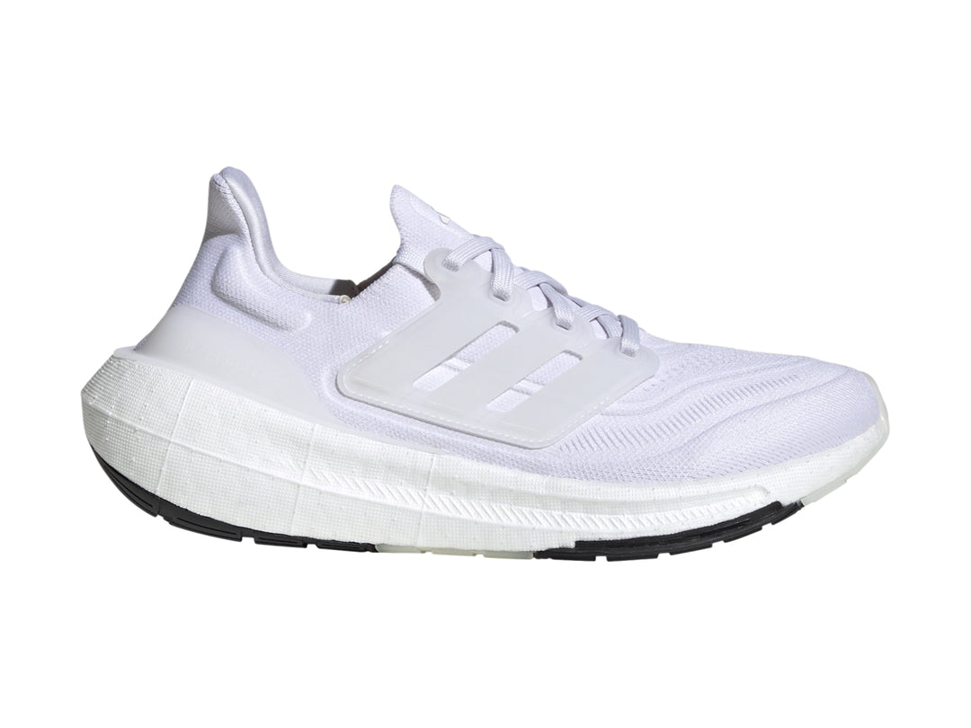 Tenis Adidas Ultraboost Light color blanco con suela negra.