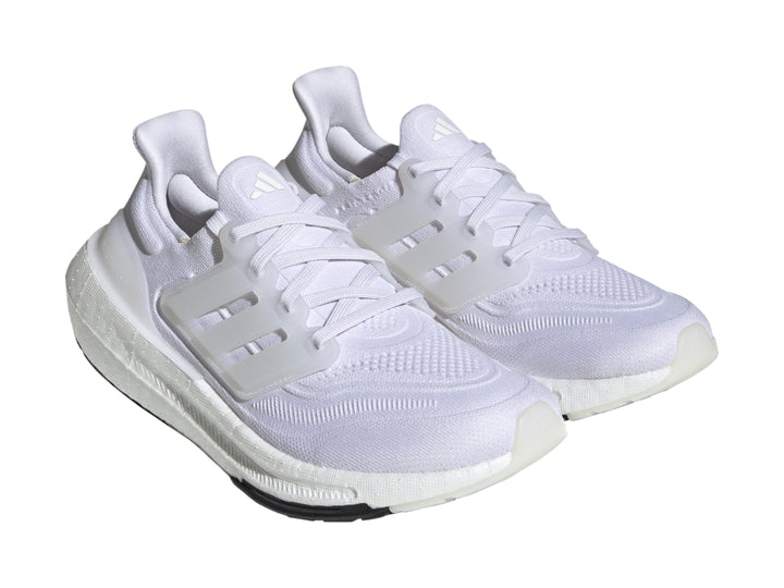 Tenis Adidas Ultraboost Light color blanco con suela negra.