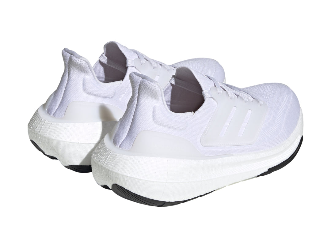 Tenis Adidas Ultraboost Light color blanco con suela negra.