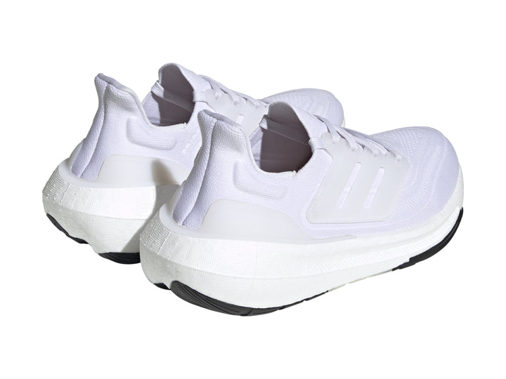Tenis Adidas Ultraboost Light color blanco con suela negra.