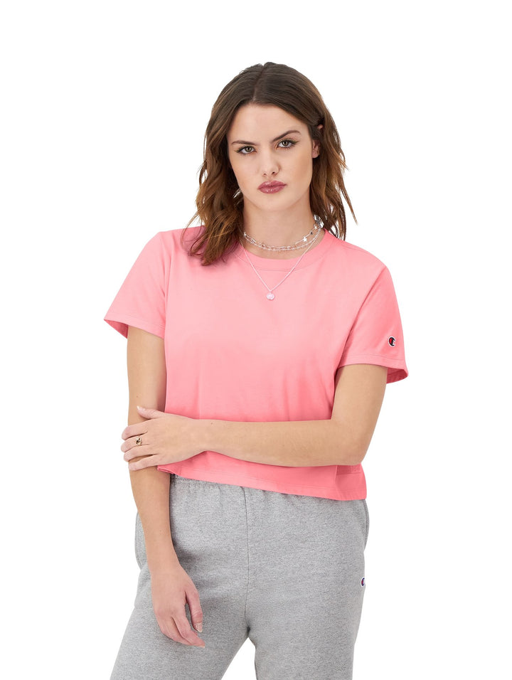Mujer modelando una camiseta rosa de manga corta y cuello redondo de la marca Champion.