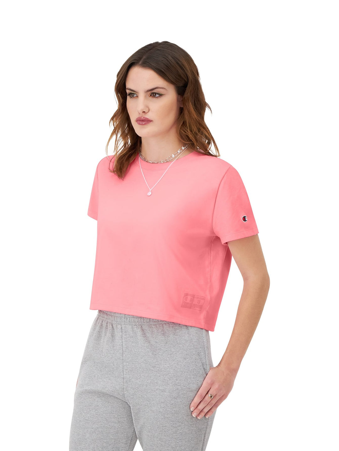 Mujer modelando una camiseta rosa de manga corta y cuello redondo de la marca Champion.