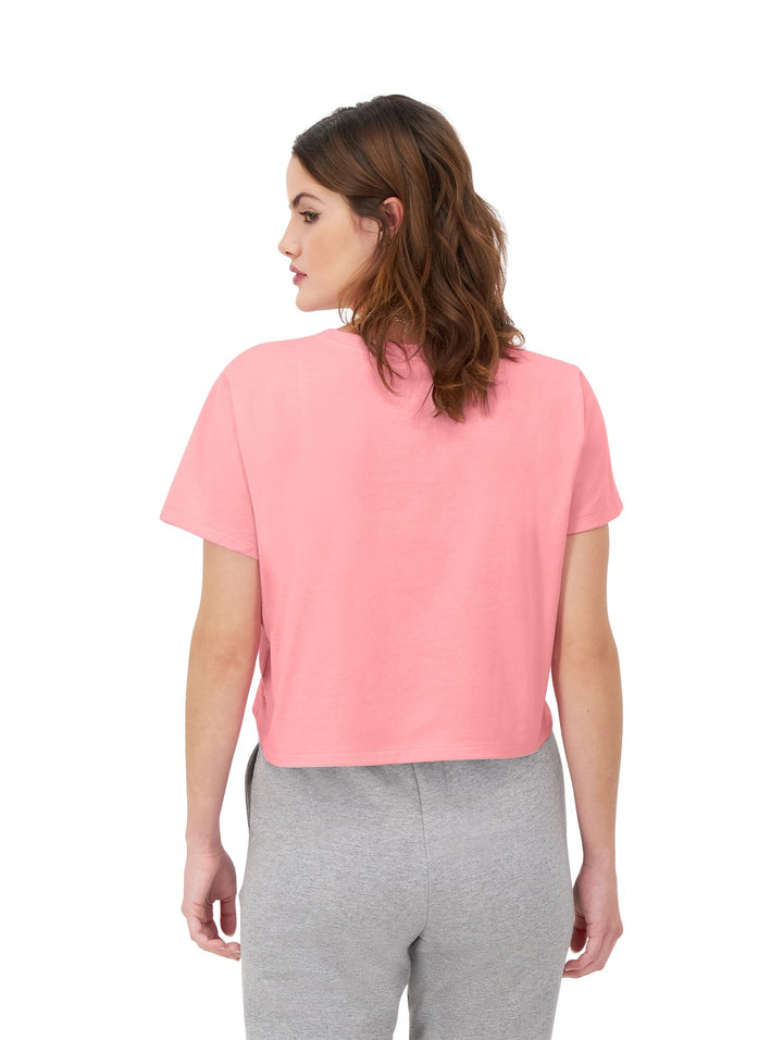Mujer modelando una camiseta rosa de manga corta y cuello redondo de la marca Champion.