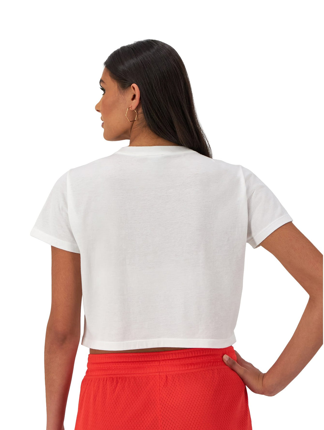 Mujer vistiendo una camiseta blanca corta de marca Champion con logotipo colorido en el pecho.
