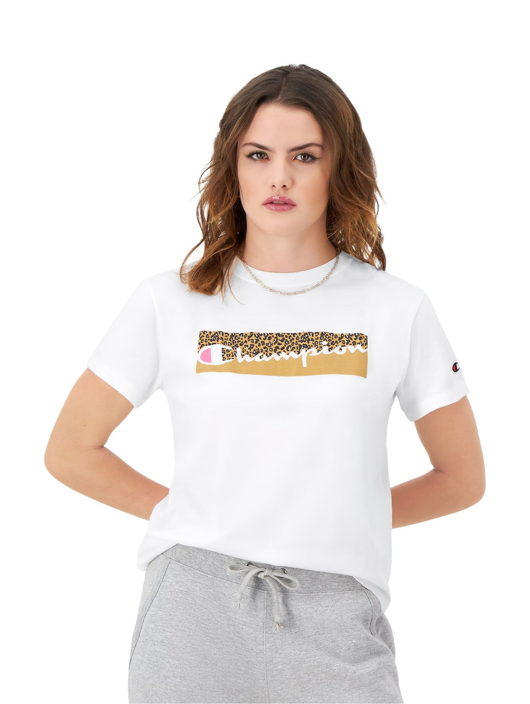 Mujer vistiendo una playera blanca de manga corta marca Champion con logotipo frontal en estampado de leopardo.