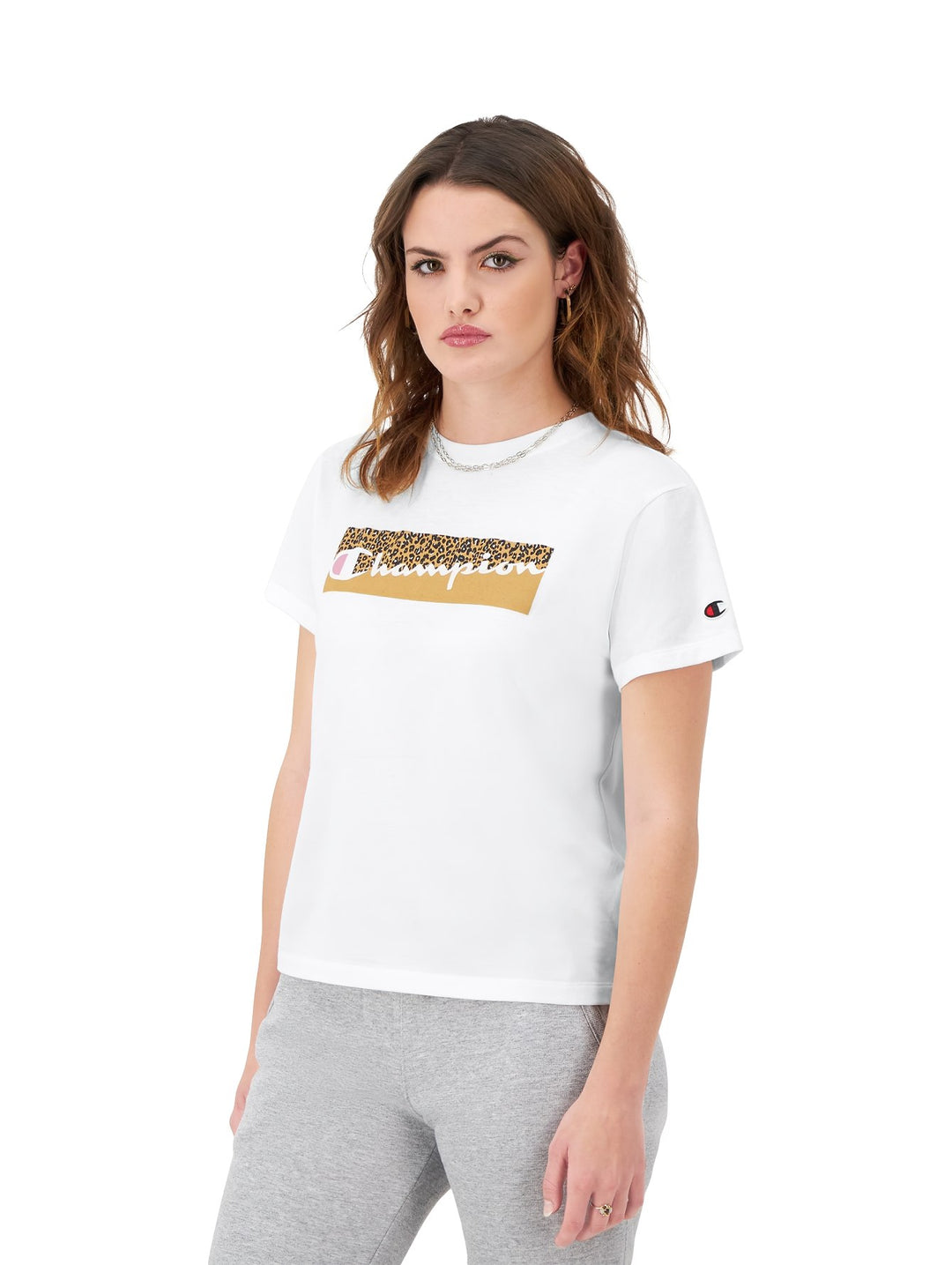 Mujer vistiendo una playera blanca de manga corta marca Champion con logotipo frontal en estampado de leopardo.