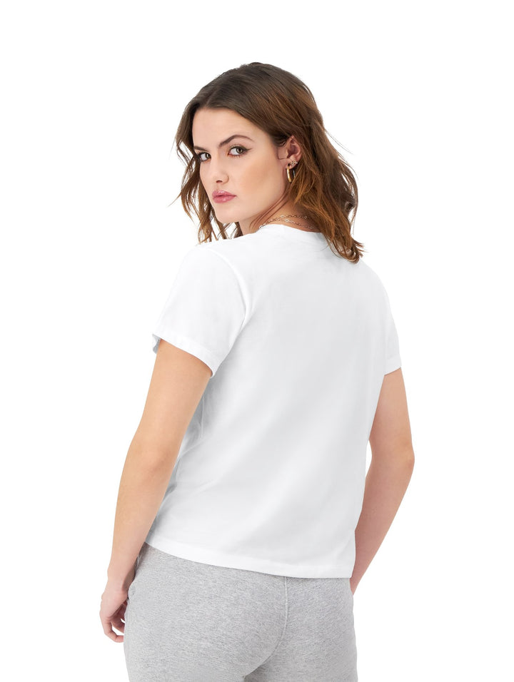 Mujer vistiendo una playera blanca de manga corta marca Champion con logotipo frontal en estampado de leopardo.