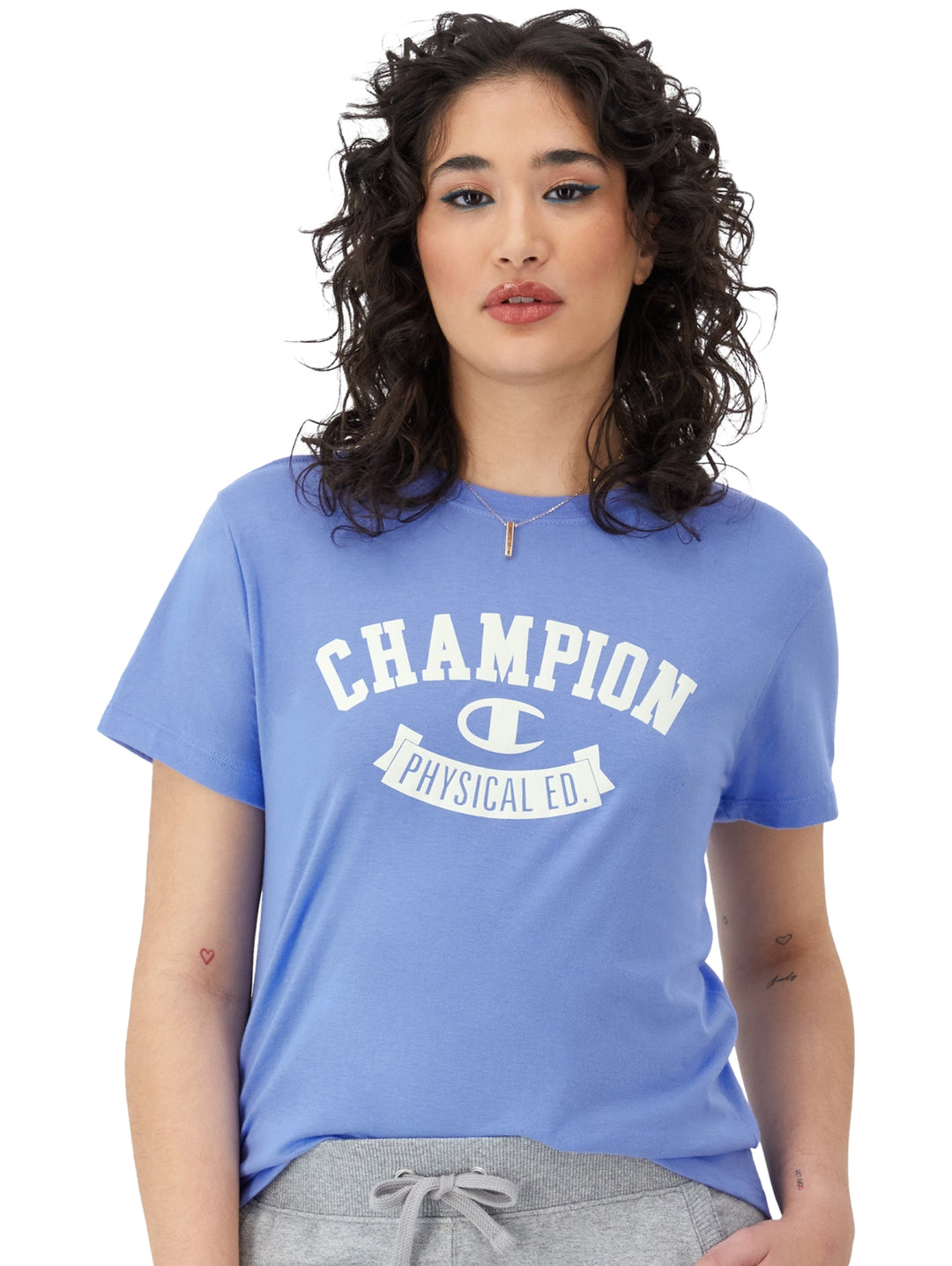 Camiseta azul claro de manga corta con estampado blanco de Champion en el pecho.