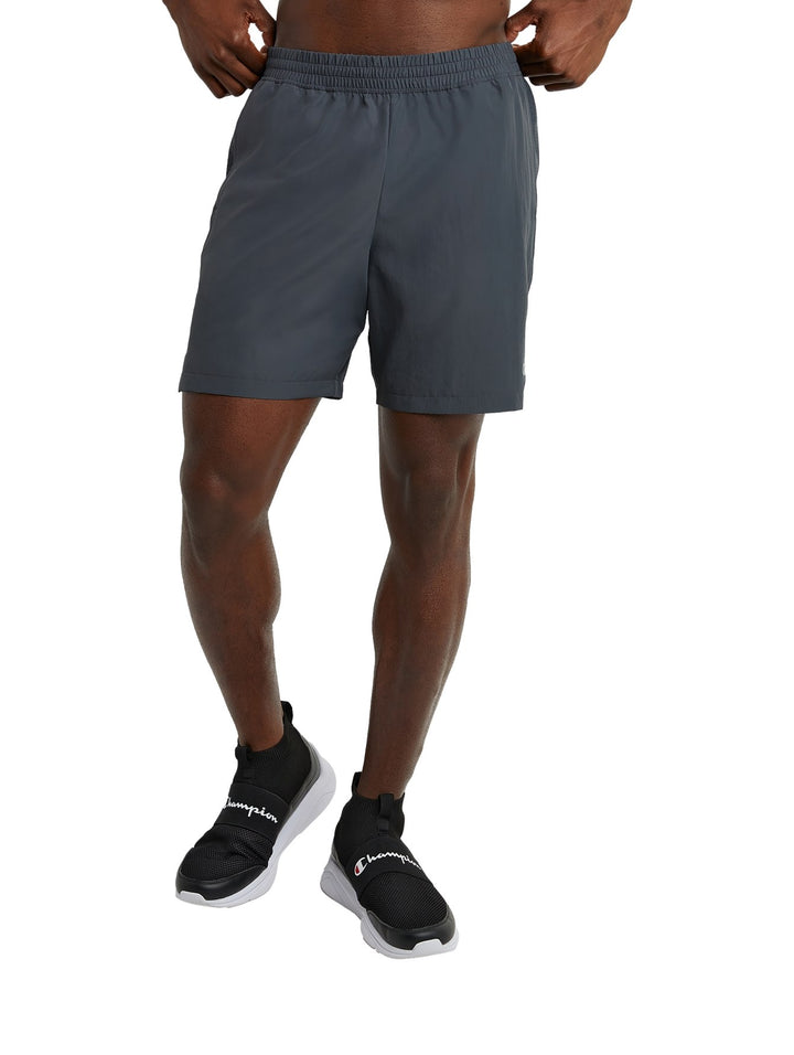 Hombre vistiendo shorts deportivos color gris oscuro de la marca Champion.
