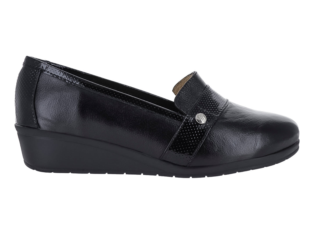 Zapato negro de cuña con correa frontal perforada y botón metálico.