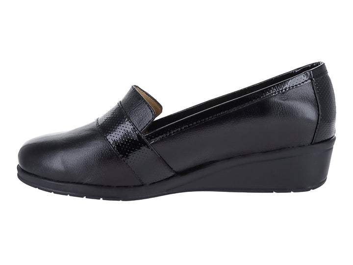 Zapato negro de cuña con correa frontal perforada y botón metálico.