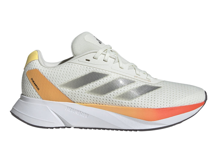 Tenis Adidas Duramo SL color marfil con detalles en naranja y franjas plateadas laterales.
