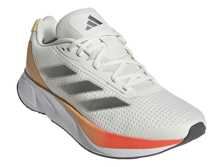 Tenis Adidas Duramo SL color marfil con detalles en naranja y franjas plateadas laterales.
