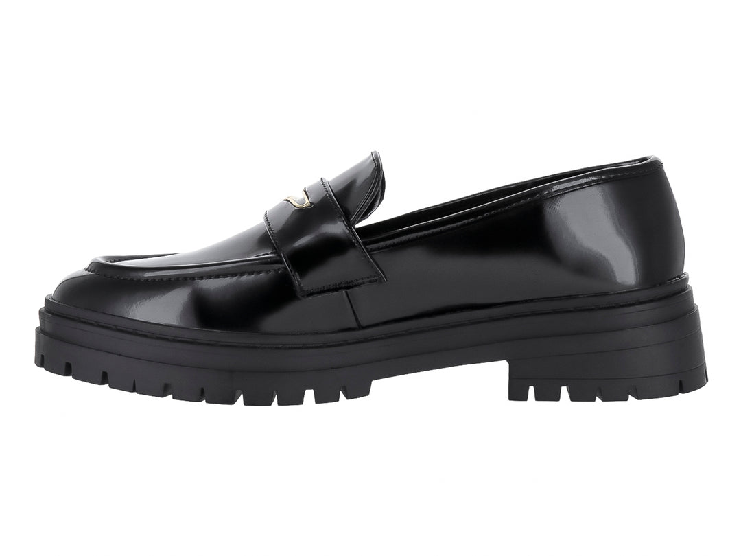 Zapato tipo mocasín negro de alto brillo con suela track gruesa y detalle metálico.