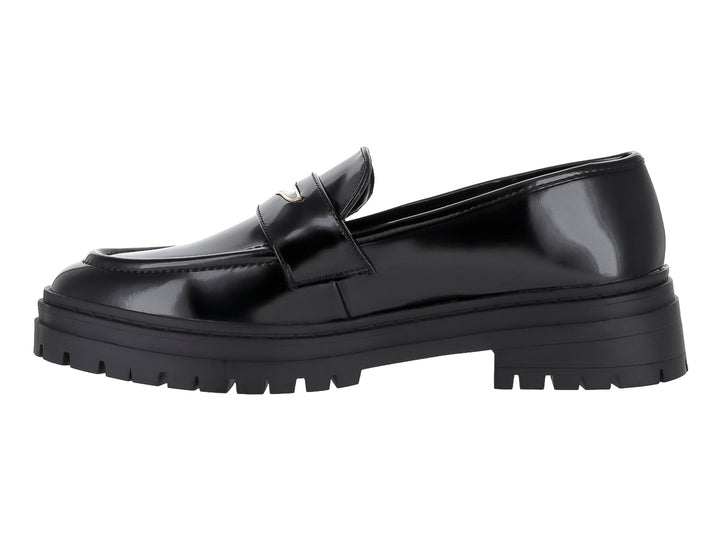 Zapato tipo mocasín negro de alto brillo con suela track gruesa y detalle metálico.