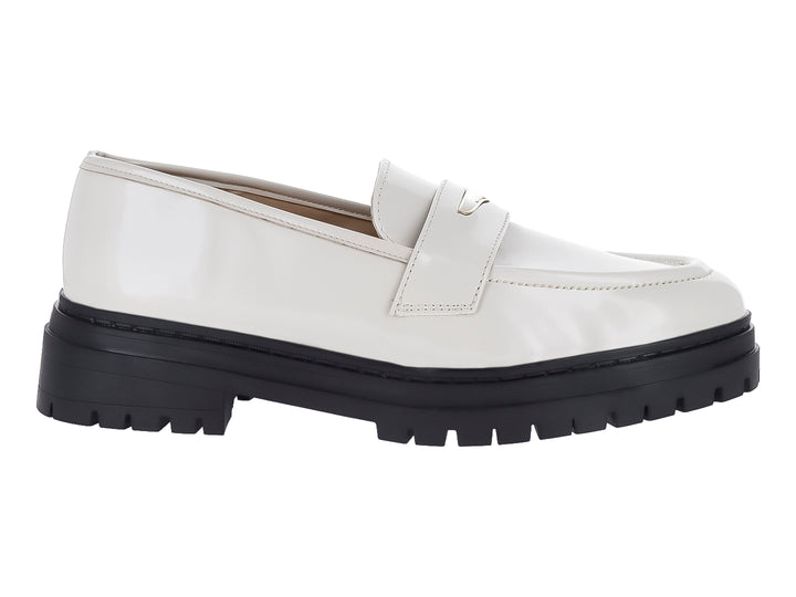 Zapato mocasín color crema de alto brillo con suela track negra gruesa.