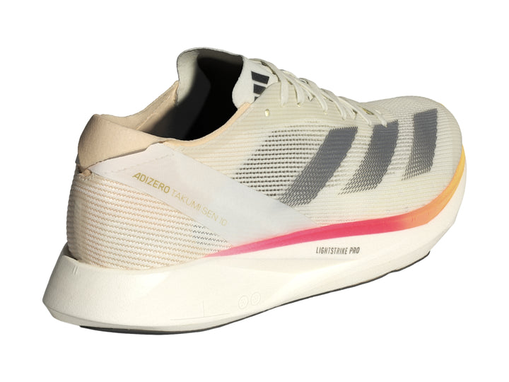 Tenis Adidas Adizero Takumi Sen 10 color marfil con franjas grises y detalle naranja en la punta.